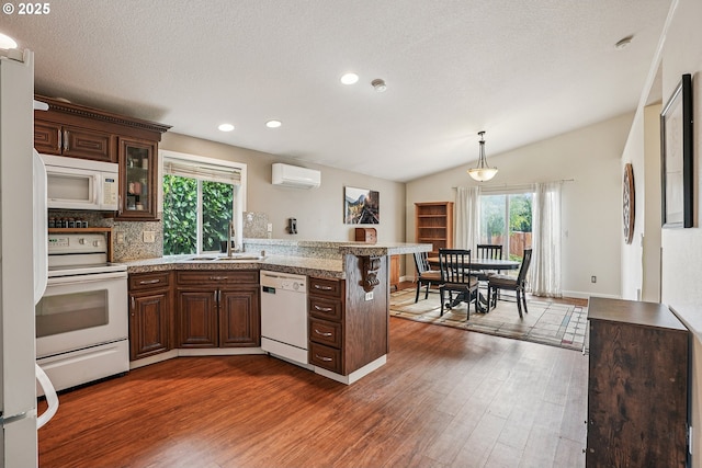 2812 NE Delancey Ct, Vancouver, WA 98682 - kitchen featuring white appliances, a peninsula, wood finished floors, light countertops, and recessed lighting