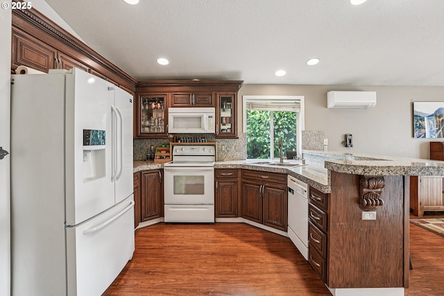 2812 NE Delancey Ct, Vancouver, WA 98682 - kitchen featuring white appliances, a wall mounted air conditioner, a peninsula, dark wood-type flooring, and recessed lighting