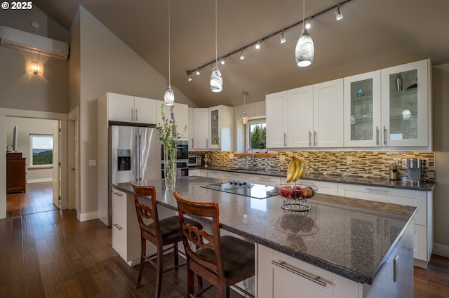 kitchen with white cabinets, stainless steel fridge with ice dispenser, a wall unit AC, backsplash, and a kitchen island