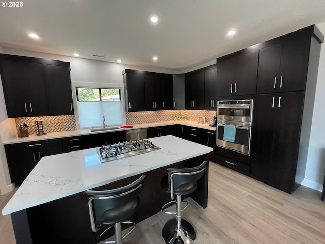 113 NW Willard St, Stevenson, WA 98648 - kitchen with dark cabinets, stainless steel appliances, a center island, a sink, and recessed lighting