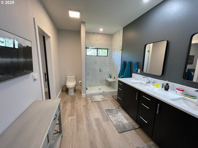 full bathroom with toilet, a marble finish shower, a sink, and wood finished floors