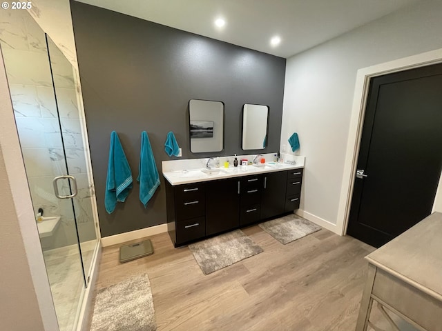 113 NW Willard St, Stevenson, WA 98648 - bathroom with wood finished floors, double vanity, a marble finish shower, baseboards, and recessed lighting