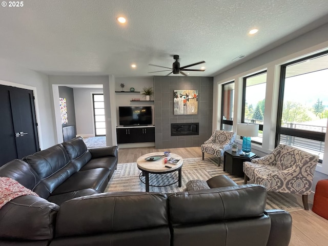 113 NW Willard St, Stevenson, WA 98648 - living area featuring a textured ceiling, ceiling fan, light wood-style flooring, a tiled fireplace, and recessed lighting