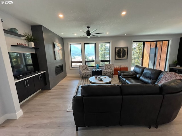 113 NW Willard St, Stevenson, WA 98648 - living area with a large fireplace, recessed lighting, ceiling fan, baseboards, and light wood-type flooring