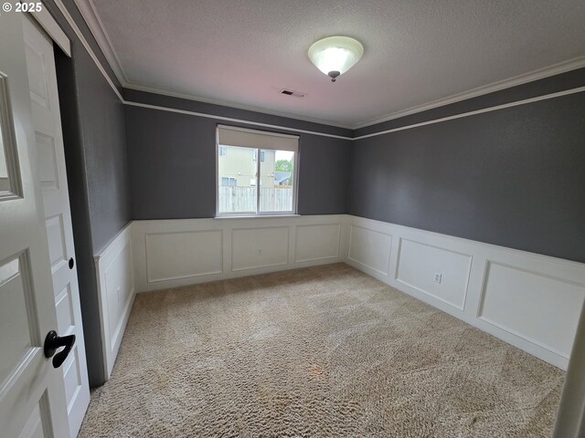 15503 NE 84th St, Vancouver, WA 98682 - unfurnished room featuring a textured ceiling, crown molding, a decorative wall, wainscoting, and light carpet