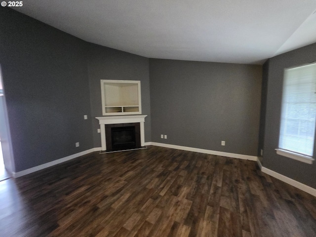 15503 NE 84th St, Vancouver, WA 98682 - unfurnished living room featuring vaulted ceiling, dark wood-style flooring, a fireplace with raised hearth, and baseboards