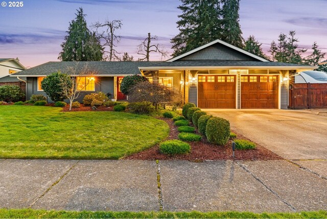 single story home with driveway, a garage, a lawn, and fence