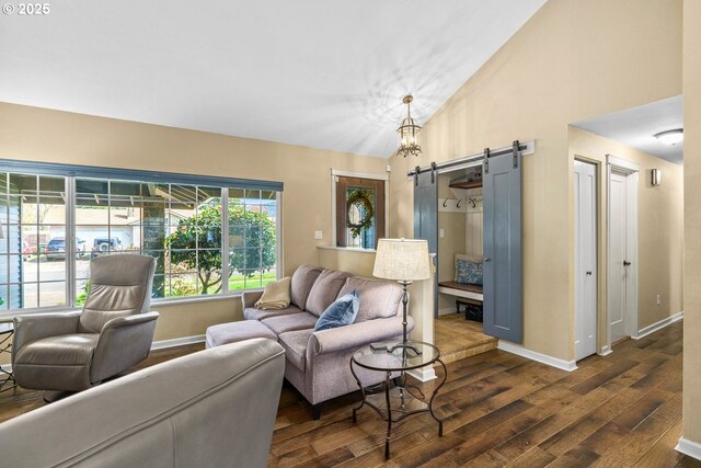 living room featuring baseboards, a barn door, vaulted ceiling, and dark wood finished floors