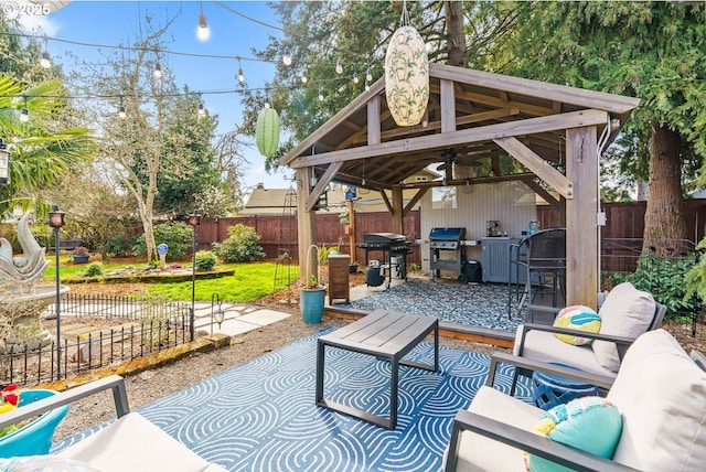 view of patio / terrace featuring a grill, ceiling fan, a fenced backyard, and a gazebo