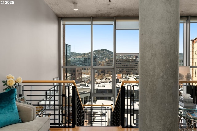 interior space with a view of city, wood finished floors, and floor to ceiling windows