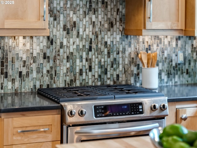 2487 Southslope Way W, Linn, OR 97068 - kitchen view of stainless steel gas range oven, decorative backsplash, dark countertops, and light brown cabinets