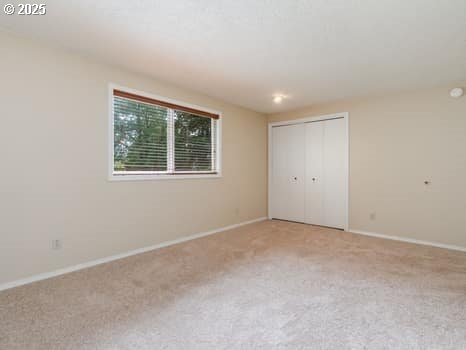 2487 Southslope Way W, Linn, OR 97068 - unfurnished bedroom with carpet flooring, baseboards, and a closet