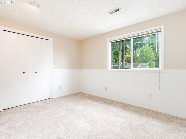 2487 Southslope Way W, Linn, OR 97068 - unfurnished bedroom with carpet floors, a textured ceiling, a closet, and baseboards