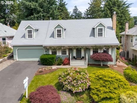 2487 Southslope Way W, Linn, OR 97068 - cape cod house with driveway, a porch, an attached garage, and a chimney