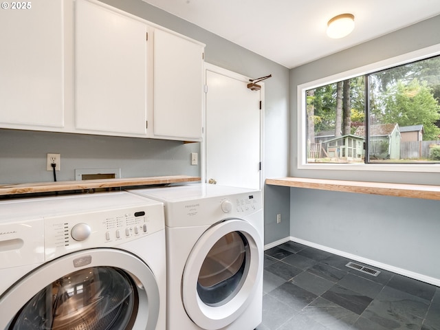 2487 Southslope Way W, Linn, OR 97068 - laundry area featuring washing machine and dryer, cabinet space, and baseboards