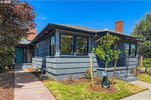 815/821 NE Holman St, Portland, OR 97211 - view of front of house featuring a chimney and a shingled roof