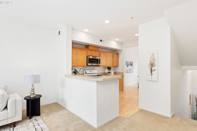2732 NW Kennedy Ct, Portland, OR 97229 - kitchen featuring stainless steel microwave, white gas stove, light carpet, a peninsula, and recessed lighting