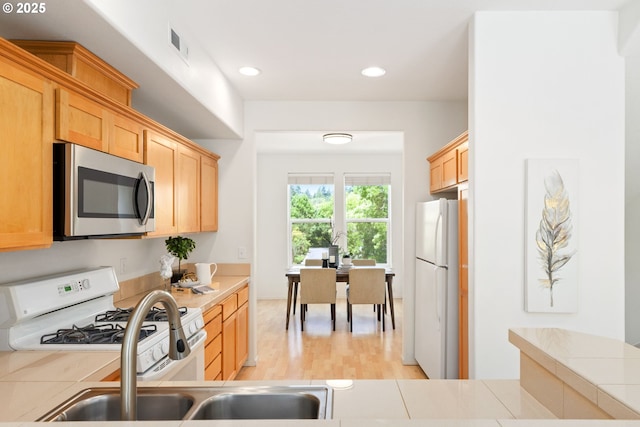 2732 NW Kennedy Ct, Portland, OR 97229 - kitchen featuring white appliances, light wood finished floors, light brown cabinetry, light countertops, and recessed lighting