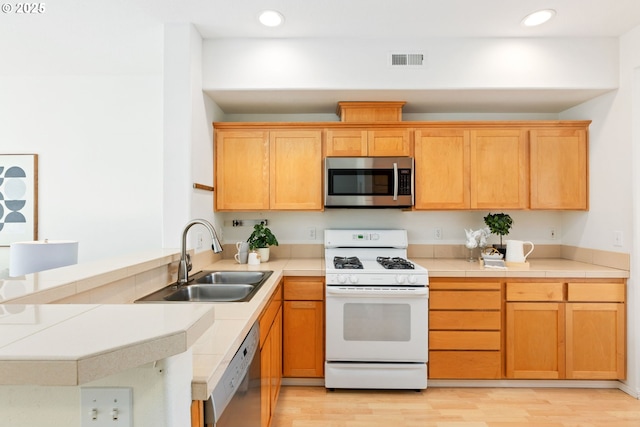 2732 NW Kennedy Ct, Portland, OR 97229 - kitchen featuring appliances with stainless steel finishes, light wood-style flooring, recessed lighting, and a peninsula