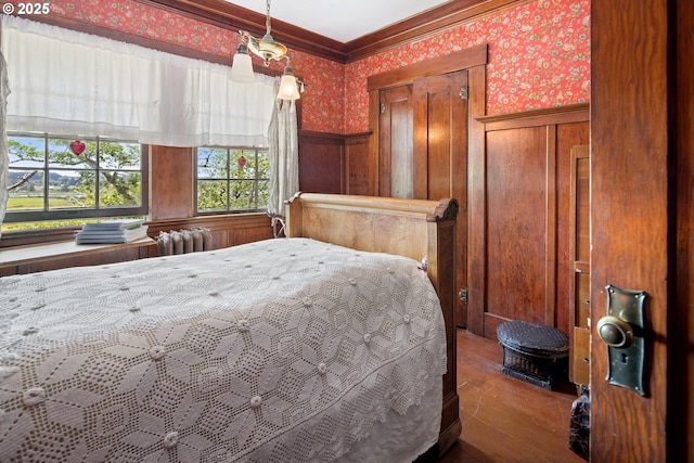 91755 Lewis And Clark Rd, Astoria, OR 97103 - bedroom with wallpapered walls, a wainscoted wall, wood finished floors, ornamental molding, and radiator
