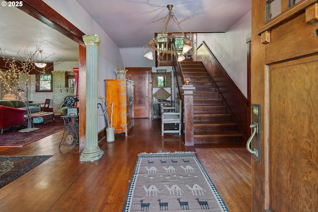 91755 Lewis And Clark Rd, Astoria, OR 97103 - foyer entrance featuring a chandelier, wood finished floors, stairs, and decorative columns