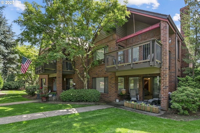 15565 SW 114th Ct Unit 23, Portland, OR 97224 - view of front of home featuring a balcony, brick siding, and a front lawn