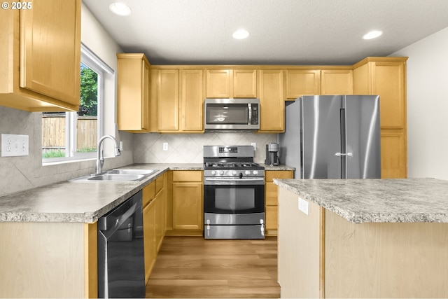 37125 Goldenrain St, Sandy, OR 97055 - kitchen with stainless steel appliances, light wood-style floors, tasteful backsplash, light countertops, and recessed lighting