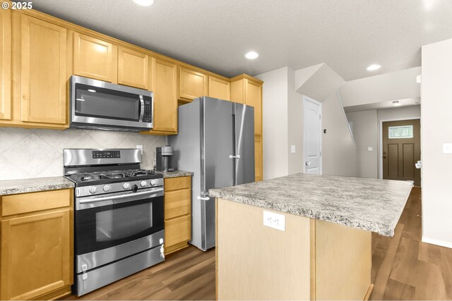 37125 Goldenrain St, Sandy, OR 97055 - kitchen with appliances with stainless steel finishes, dark wood-style floors, backsplash, a center island, and recessed lighting
