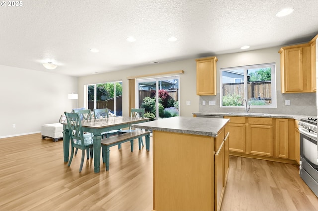 37125 Goldenrain St, Sandy, OR 97055 - kitchen with light brown cabinets, light wood-type flooring, a textured ceiling, a kitchen island, and gas range
