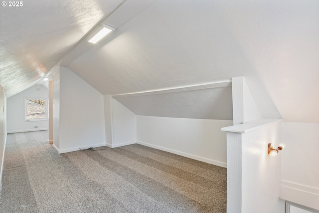 bonus room featuring lofted ceiling, carpet floors, and a textured ceiling