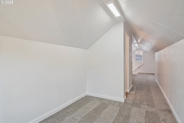 bonus room featuring lofted ceiling, carpet flooring, and a textured ceiling