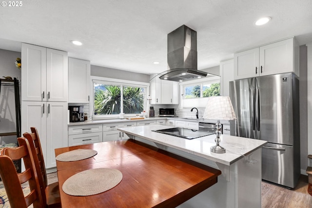 48521 E 1st St, Oakridge, OR 97463 - kitchen with appliances with stainless steel finishes, island range hood, a sink, tasteful backsplash, and white cabinetry