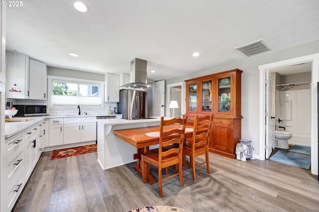 48521 E 1st St, Oakridge, OR 97463 - kitchen featuring island range hood, appliances with stainless steel finishes, a sink, tasteful backsplash, and light countertops
