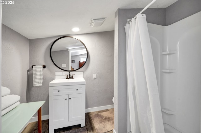 48521 E 1st St, Oakridge, OR 97463 - bathroom with a textured wall, vanity, wood finished floors, baseboards, and a shower with shower curtain