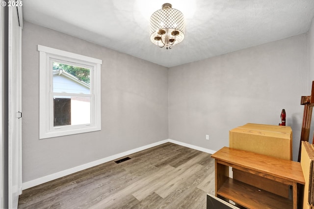 48521 E 1st St, Oakridge, OR 97463 - empty room featuring wood finished floors, a chandelier, and baseboards