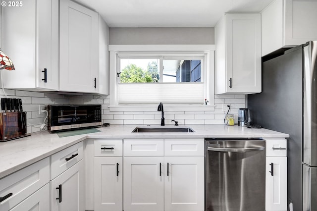 48521 E 1st St, Oakridge, OR 97463 - kitchen featuring appliances with stainless steel finishes, a sink, tasteful backsplash, white cabinets, and light stone countertops