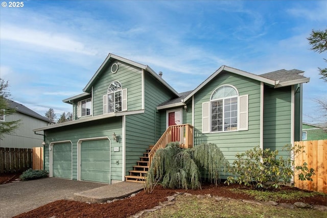 view of front of home featuring a garage, driveway, and fence