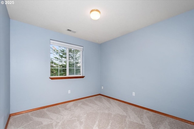 carpeted spare room with visible vents and baseboards