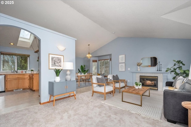 living area with lofted ceiling, a fireplace, visible vents, and light carpet