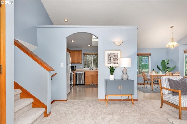 interior space featuring light carpet, baseboards, arched walkways, stairs, and recessed lighting