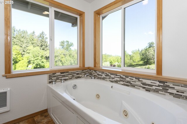 bathroom featuring a tub with jets and baseboards