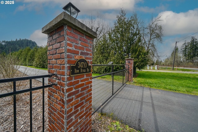 view of gate with a yard and fence