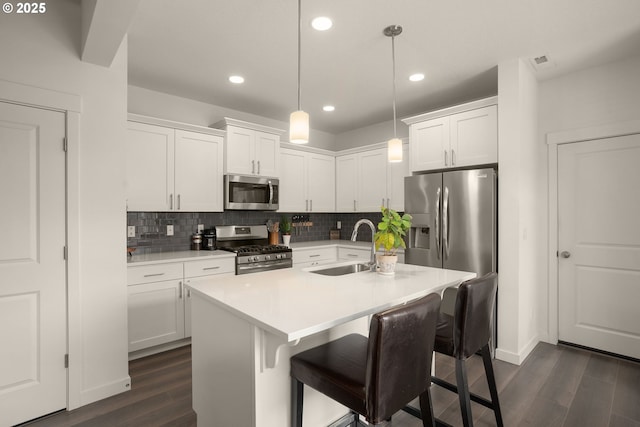 833 S 25th Ter, Cornelius, OR 97113 - kitchen featuring appliances with stainless steel finishes, dark wood-style flooring, tasteful backsplash, white cabinetry, and light countertops