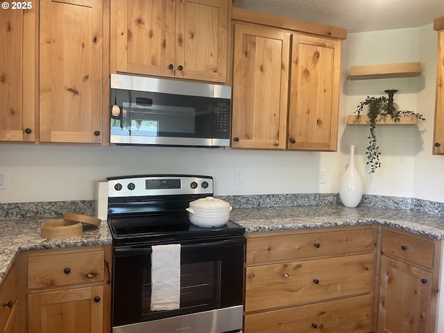 440 NW Gutbrod St, Sheridan, OR 97378 - kitchen with stainless steel microwave, range with electric stovetop, light brown cabinetry, and light stone countertops