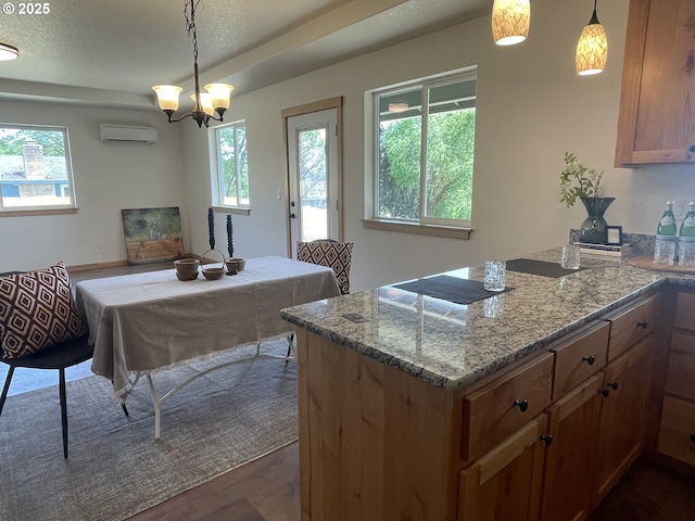 440 NW Gutbrod St, Sheridan, OR 97378 - kitchen featuring plenty of natural light, an AC wall unit, light stone countertops, and a peninsula