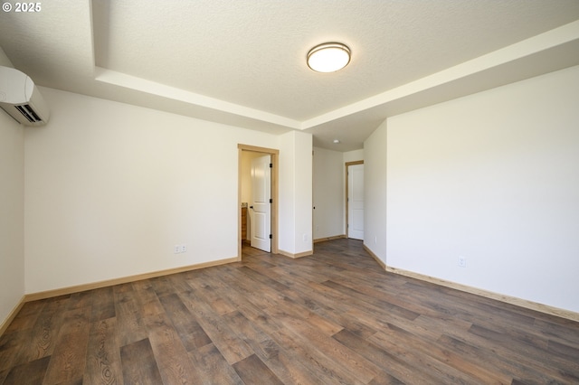 440 NW Gutbrod St, Sheridan, OR 97378 - unfurnished room with dark wood-type flooring, a raised ceiling, an AC wall unit, and baseboards