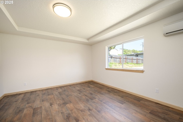 440 NW Gutbrod St, Sheridan, OR 97378 - spare room with a textured ceiling, a tray ceiling, baseboards, wood finished floors, and a wall mounted air conditioner