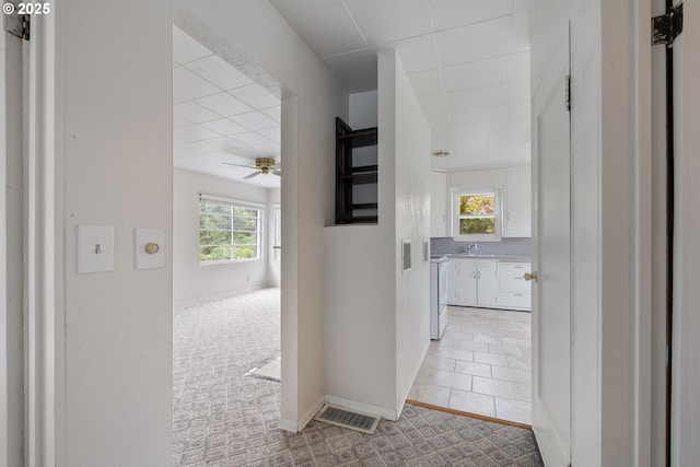 1421 SW Fleet Ave, Lincoln City, OR 97367 - hall featuring a sink, light carpet, and baseboards