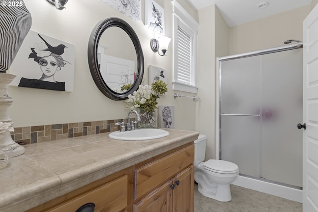 bathroom featuring a shower with door, vanity, decorative backsplash, and toilet