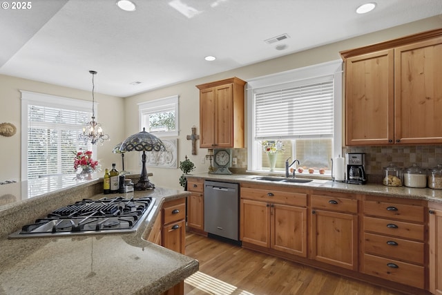 kitchen with sink, a chandelier, light hardwood / wood-style flooring, stainless steel appliances, and backsplash